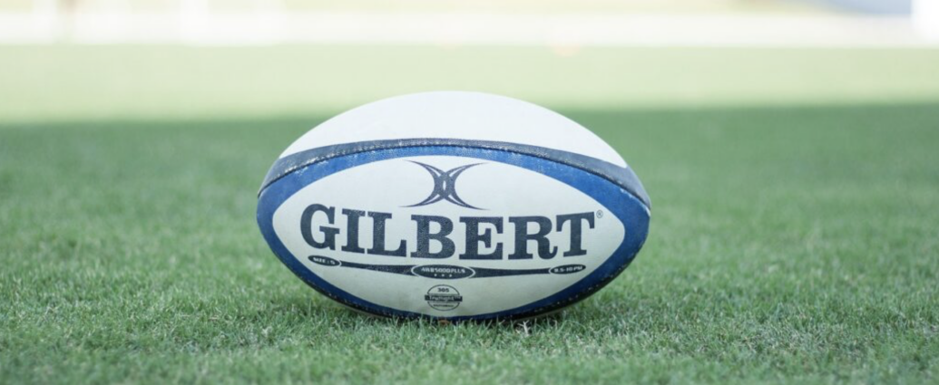 A white and blue rugby pall on green grass